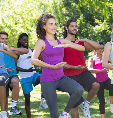 group of people doing yoga in the park